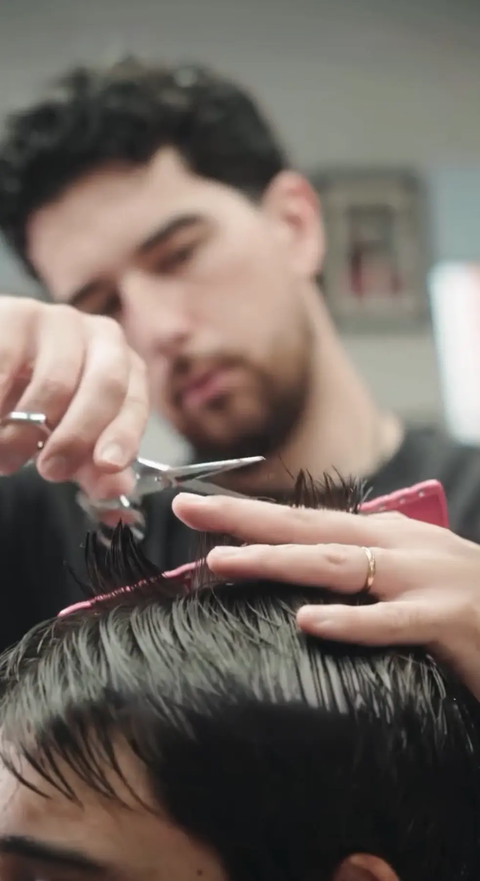 Fred a executar um corte masculino à tesoura na barbearia em Leiria