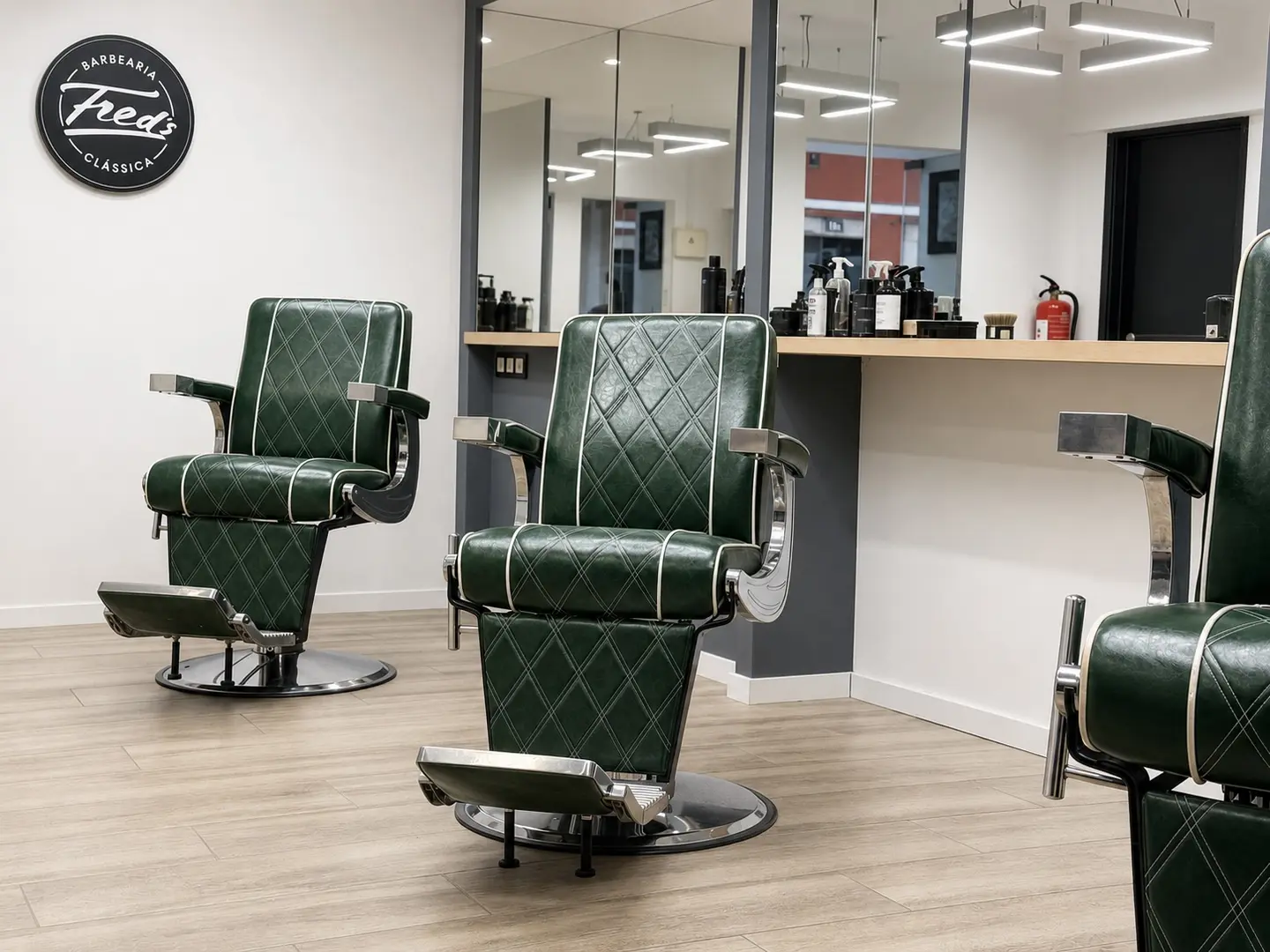 Interior da Fred’s — Barbearia Clássica em Leiria, com cadeiras de barbeiro verdes